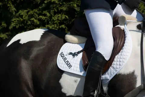 Rider on a skewbald horse with an Equiliser saddle pad