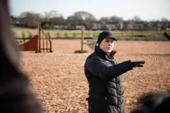 Coach giving instruction in an outdoor arena